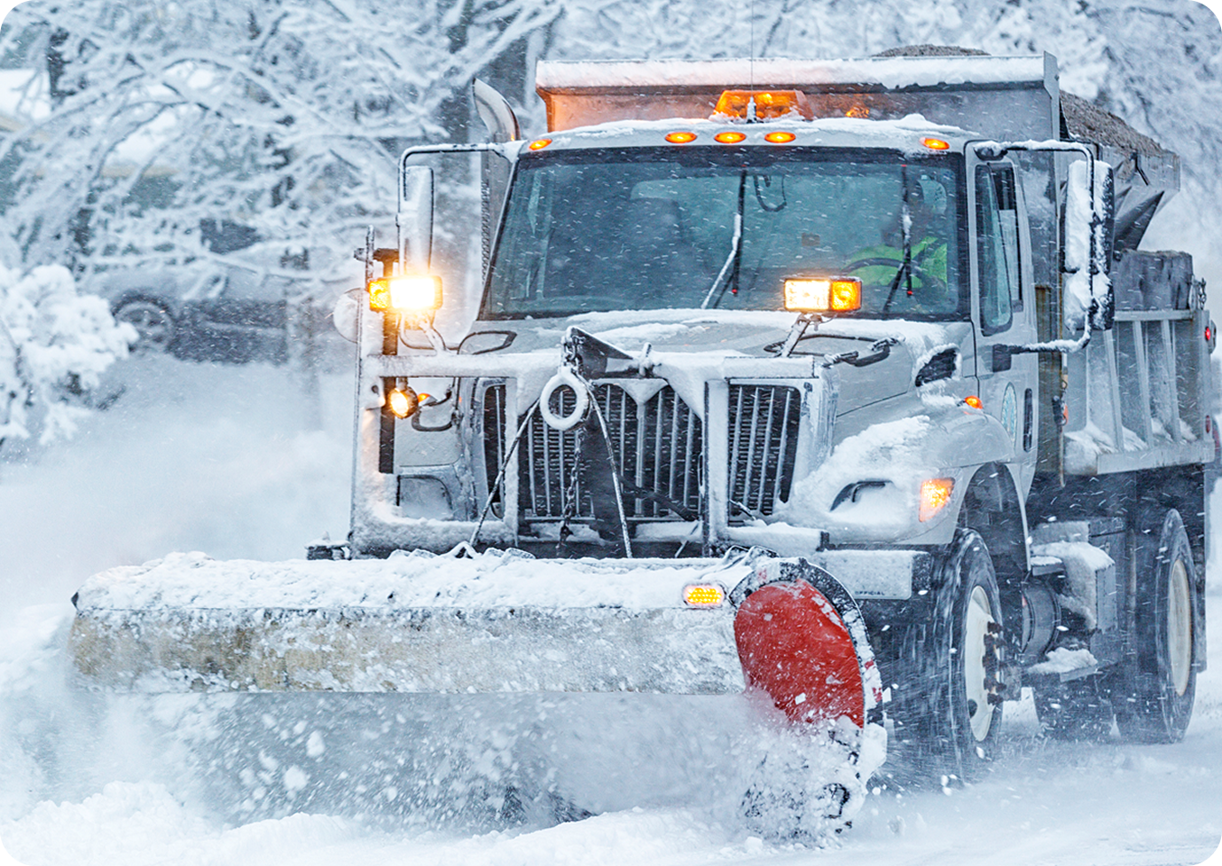 Snowplow clearing snow-covered road.