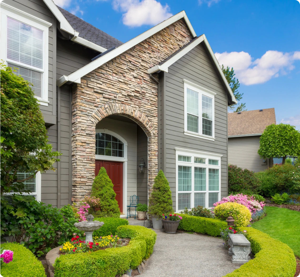 Two-story home with lush greenery